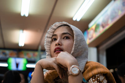 Woman in hijab looking away at restaurant