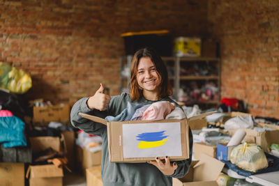 Volunteer teengirl preparing donation boxes for people in need in ukraine.