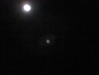 Low angle view of illuminated moon in sky at night