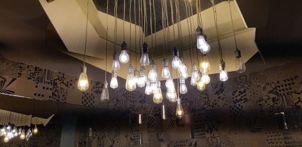 Low angle view of illuminated pendant light hanging from ceiling