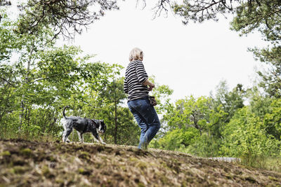 Rear view of woman with dog against plants