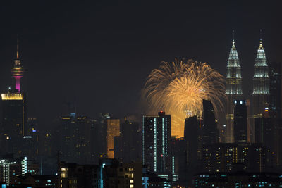 Firework display over city lit up at night