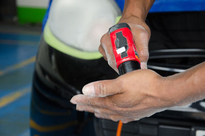 Midsection of man cleaning car at garage