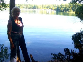 Man standing by lake against trees