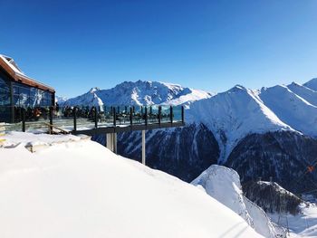 Scenic view of snow covered mountains against blue sky