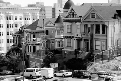 Cars on road by buildings in city