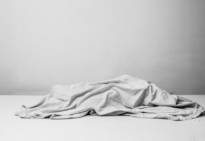 White sleeping on bed against wall