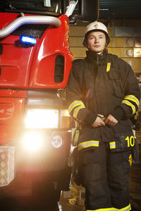 Portrait of fire fighter in front of fire engine