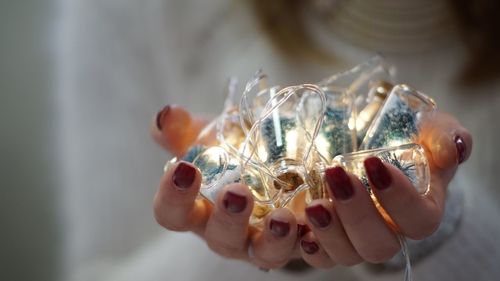 Close-up of hands holding illuminated decorations