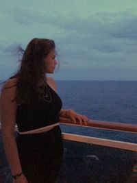 Woman looking at sea against sky