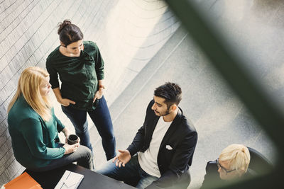 High angle view of businessman discussing with female colleagues in creative office