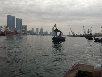 Nautical vessel on sea against buildings in city