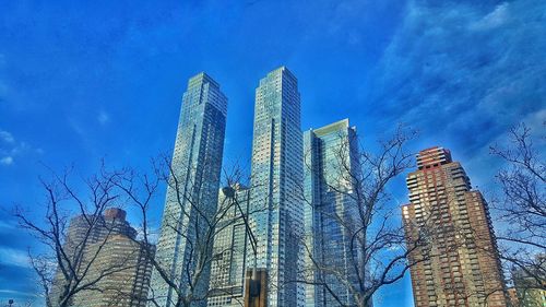 Low angle view of skyscrapers against blue sky