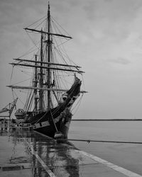 Ship moored at harbor against sky