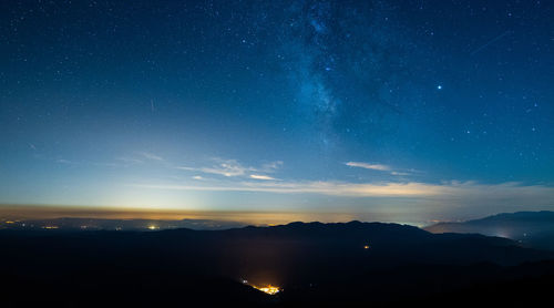 Scenic view of silhouette mountains against sky at night