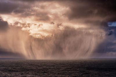 Phenomenon - the ocean feeds the clouds with a water. scenic view of sea against cloudy sky.