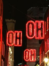 Low angle view of illuminated sign at night