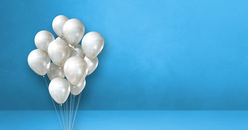 Close-up of white balloons against blue background