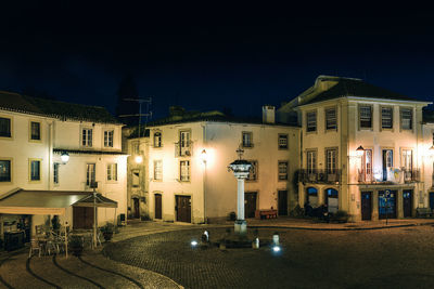 Illuminated buildings against sky at night