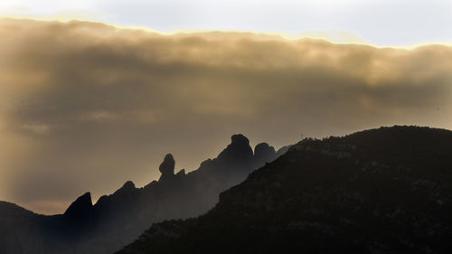 Scenic view of silhouette mountains against sky during sunset