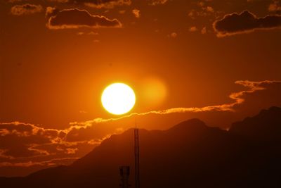 Scenic view of silhouette mountains against orange sky