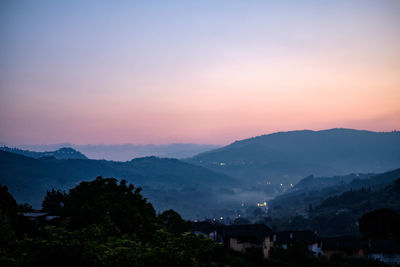 Scenic view of silhouette mountains against sky at sunset