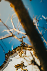 Low angle view of cross against sky