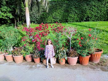 View of girl standing by potted plants