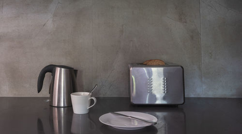 Coffee cup on table against wall