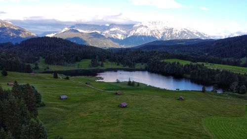 Scenic view of green landscape and mountains against sky