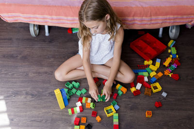 High angle view of girl playing with toy blocks