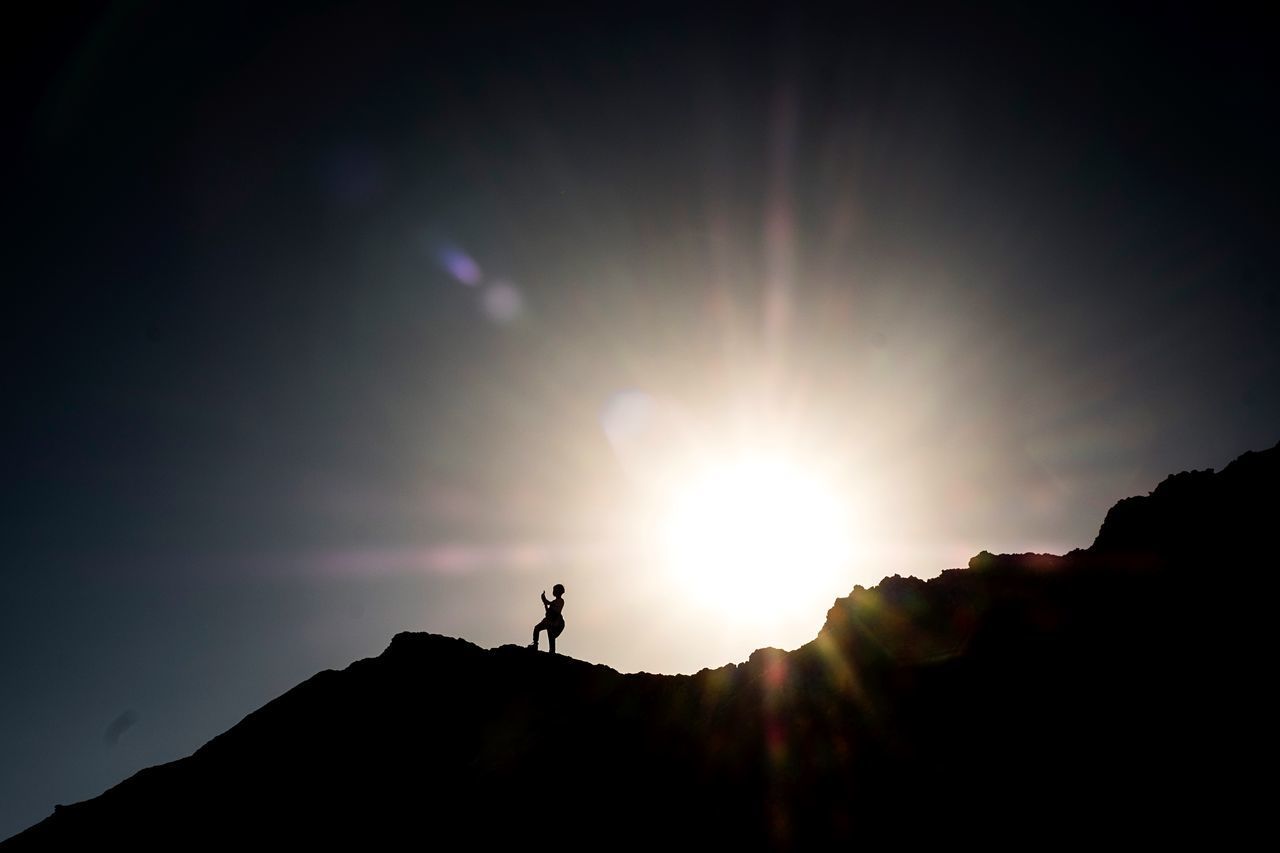 LOW ANGLE VIEW OF SILHOUETTE PERSON AGAINST SKY