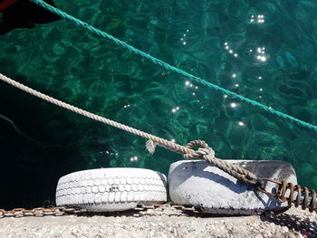 High angle view of rope tied to fishing net at harbor