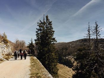 People walking on mountain against sky
