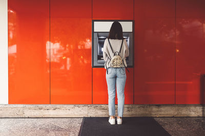 Rear view of woman standing against wall