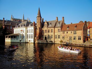 Boats in river with buildings in background