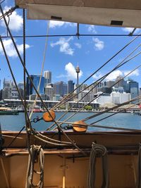 Sailboats moored in city against sky