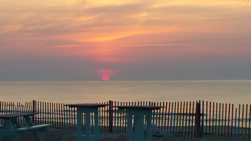 Scenic view of sea against dramatic sky during sunset