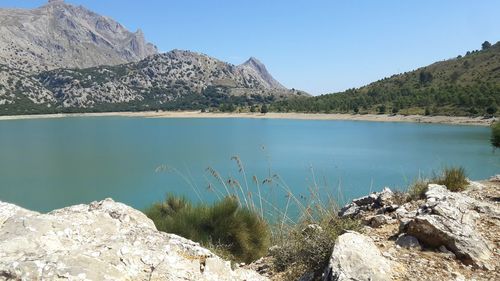 Scenic view of lake and mountains against blue sky