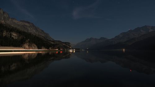 Idyllic shot of mountains against sky with reflection in sea