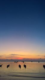 Boats in sea against sky during sunset