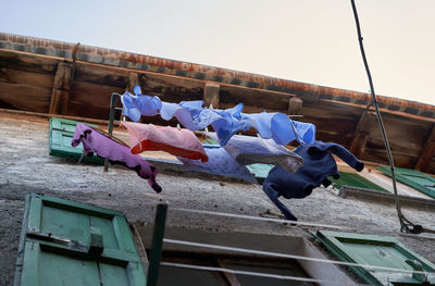 Low angle view of clothes drying against blue sky