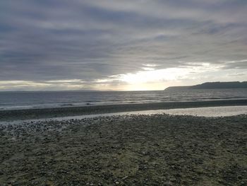 Scenic view of beach against sky during sunset