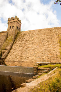 Stone wall of fort against cloudy sky