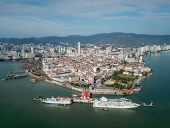 High angle view of city by sea against sky