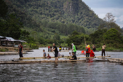 People at riverbank during rainy season