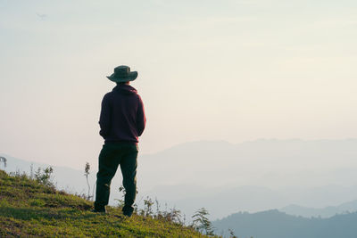 Hiker man relax with wellbeing and happy feeling on top of mountain