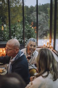 Senior female friends talking to each other during dinner party