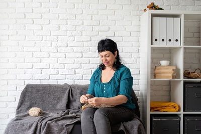 Woman sitting on sofa at home