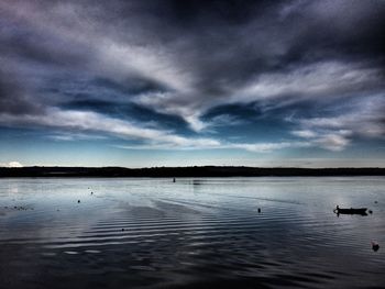 Scenic view of lake against cloudy sky